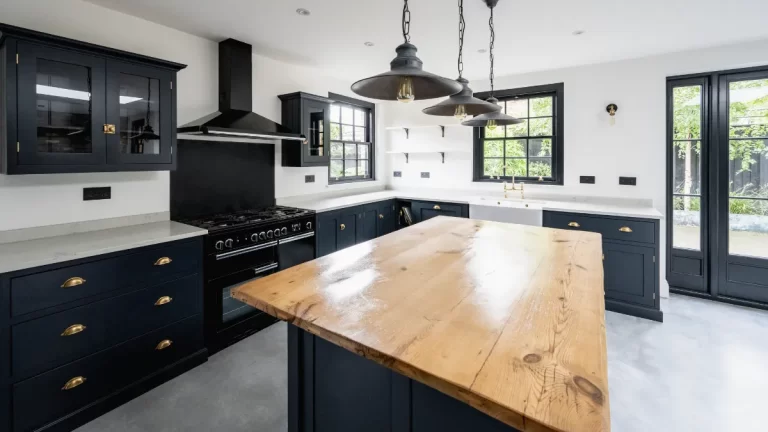 Modern kitchen extension featuring navy blue cabinets, a wooden island, and stylish pendant lighting.